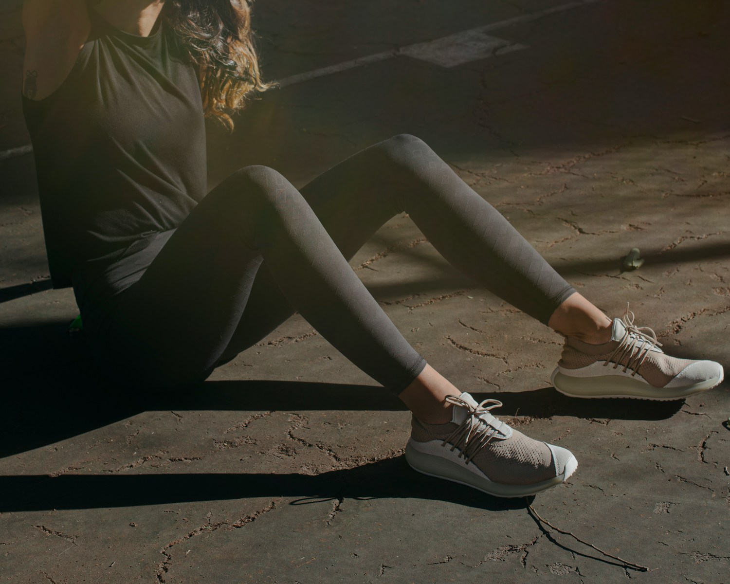 a woman sitting on the ground with her legs crossed