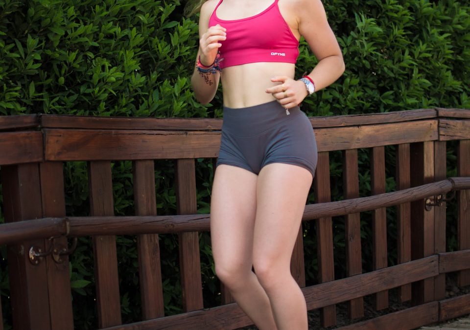 Young woman jogging on a wooden path outdoors.