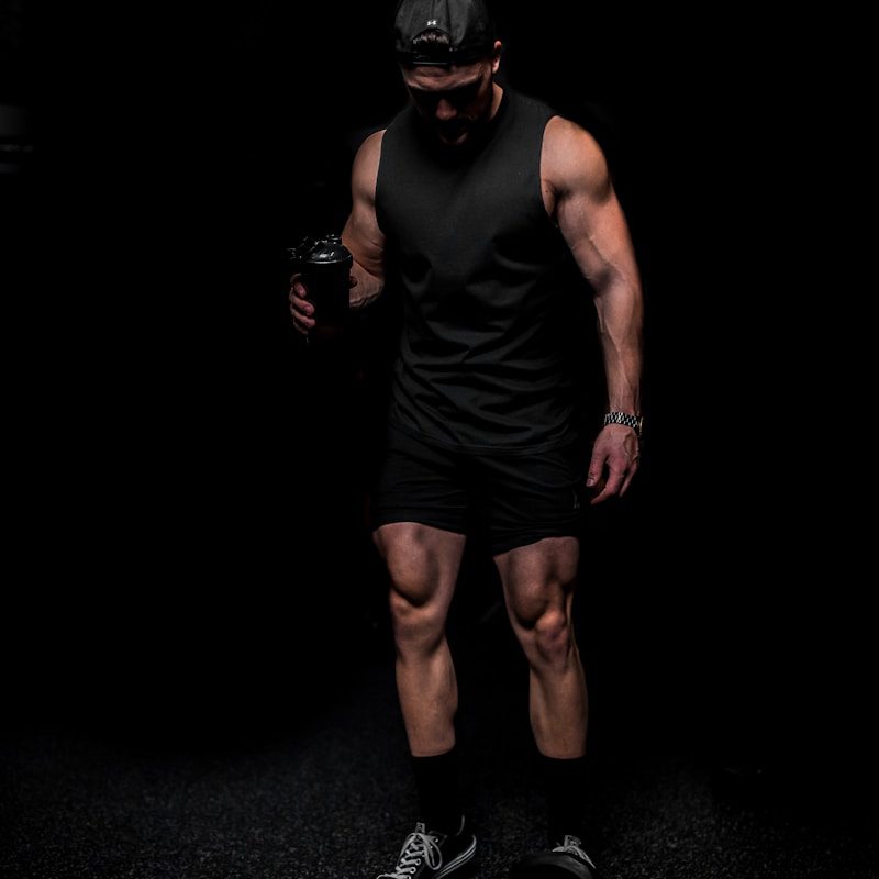 man in black tank top and shorts wearing black mask
